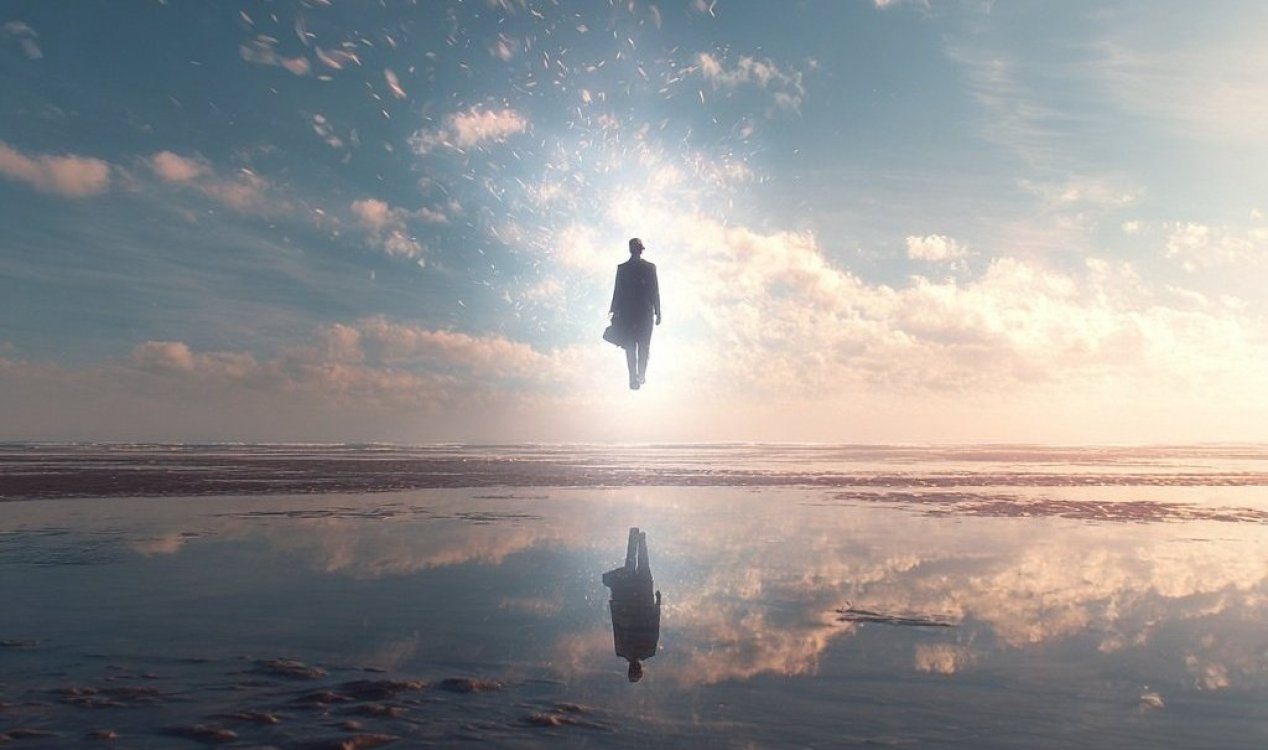 Surreal human silhouette facing a luminous portal