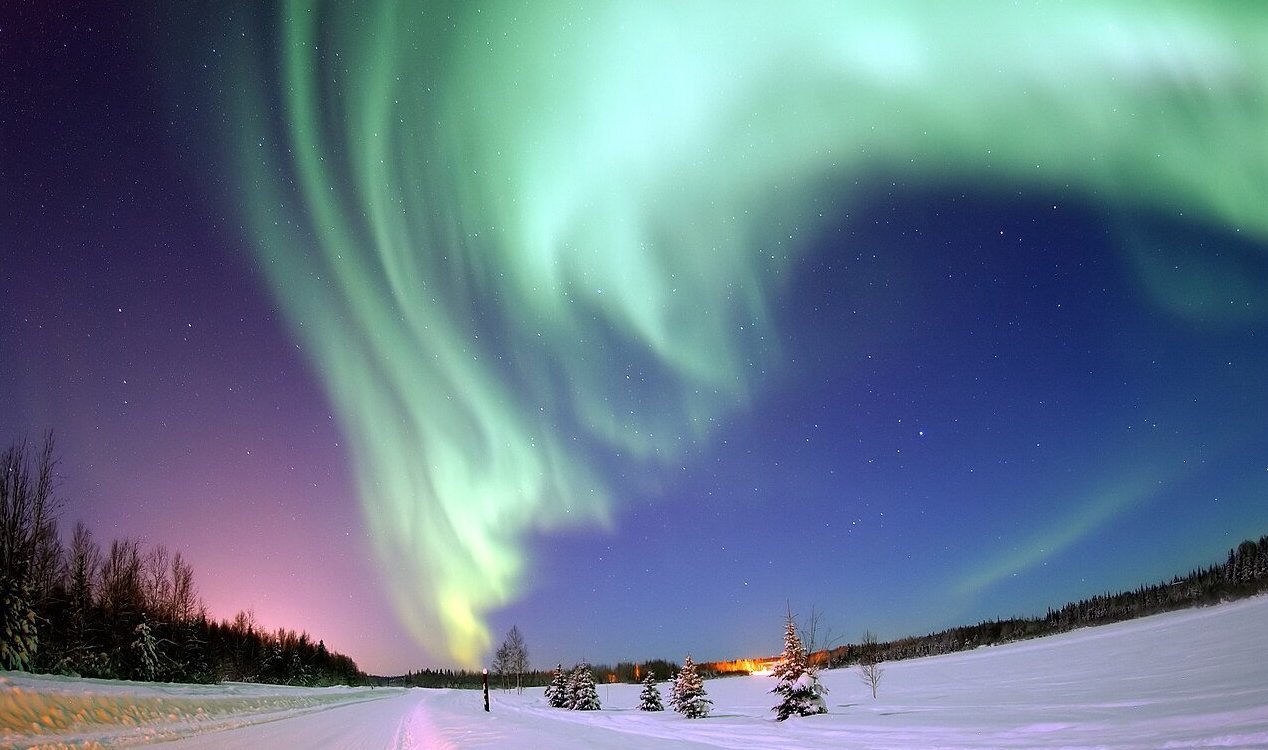 Aurora borealis glowing above a snowy landscape